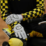 Person wearing a black and yellow checkered jacket with 'FORTH' branding, sitting on a dirt bike.